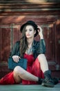 Young beautiful brunette woman with red short dress and black hat posing sensual in vintage scenery. Romantic mysterious lady Royalty Free Stock Photo