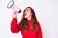 Young beautiful brunette woman screaming using megaphone over isolated white background Royalty Free Stock Photo