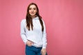 Young beautiful brunette woman with sincere emotions isolated on background wall with copy space wearing casual stylish Royalty Free Stock Photo