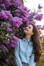 Young beautiful brunette woman is smelling lilac flower blossom in spring time Royalty Free Stock Photo