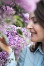 Young beautiful brunette woman is smelling lilac flower blossom in spring time Royalty Free Stock Photo