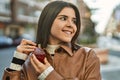 Young beautiful brunette woman smiling happy applying fragance from luxury perfume Royalty Free Stock Photo