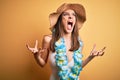 Young beautiful brunette woman on vacation wearing swimsuit and Hawaiian flowers lei crazy and mad shouting and yelling with