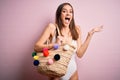 Young beautiful brunette woman on vacation wearing white swimsuit holding summer bag very happy and excited, winner expression Royalty Free Stock Photo