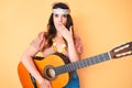 Young beautiful brunette woman wearing boho style playing classical guitar covering mouth with hand, shocked and afraid for Royalty Free Stock Photo