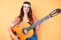 Young beautiful brunette woman wearing boho style playing classical guitar looking positive and happy standing and smiling with a Royalty Free Stock Photo