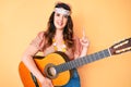 Young beautiful brunette woman wearing boho style playing classical guitar smiling with an idea or question pointing finger with Royalty Free Stock Photo