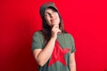 Young beautiful brunette woman wearing cap and t-shirt with red star communist symbol thinking concentrated about doubt with