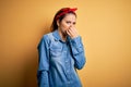 Young beautiful brunette woman wearing casual denim shirt and hair handkerchief smelling something stinky and disgusting, Royalty Free Stock Photo