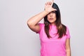 Young beautiful brunette woman wearing casual pink t-shirt standing over white background making fun of people with fingers on Royalty Free Stock Photo