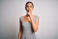 Young beautiful brunette woman wearing casual striped dress over isolated white background asking to be quiet with finger on lips Royalty Free Stock Photo