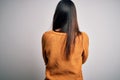 Young beautiful brunette woman wearing casual sweater over isolated white background standing backwards looking away with crossed Royalty Free Stock Photo