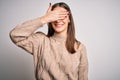 Young beautiful brunette woman wearing casual sweater standing over white background smiling and laughing with hand on face Royalty Free Stock Photo