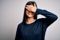 Young beautiful brunette woman wearing casual sweater standing over white background smiling and laughing with hand on face Royalty Free Stock Photo