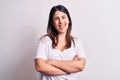 Young beautiful brunette woman wearing casual t-shirt standing over isolated white background happy face smiling with crossed arms Royalty Free Stock Photo