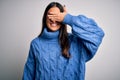 Young beautiful brunette woman wearing casual turtleneck sweater over white background smiling and laughing with hand on face Royalty Free Stock Photo