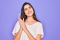 Young beautiful brunette woman wearing casual white t-shirt over purple background clapping and applauding happy and joyful, Royalty Free Stock Photo