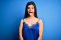 Young beautiful brunette woman wearing elegant and comfortable blue lingerie underwear sticking tongue out happy with funny Royalty Free Stock Photo