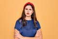 Young beautiful brunette woman wearing red lips over yellow background skeptic and nervous, disapproving expression on face with