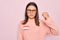 Young beautiful brunette woman wearing sticker with hello my name is message annoyed and frustrated shouting with anger, yelling