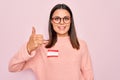 Young beautiful brunette woman wearing sticker with hello my name is message Smiling happy and positive, thumb up doing excellent Royalty Free Stock Photo