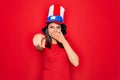 Young beautiful brunette woman wearing united states hat celebrating independence day laughing at you, pointing finger to the