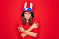 Young beautiful brunette woman wearing united states hat celebrating independence day shaking and freezing for winter cold with Royalty Free Stock Photo