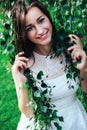 Young beautiful brunette woman in white dress in birch branches Royalty Free Stock Photo