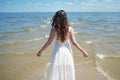 Young beautiful brunette woman in white dress on the seashore. Back view Royalty Free Stock Photo