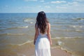 Young beautiful brunette woman in white dress on the seashore. Royalty Free Stock Photo