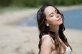 Young beautiful brunette woman in white dress on the seashore. portrait with closed eyes Royalty Free Stock Photo