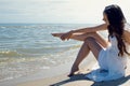 Young beautiful brunette woman in white dress on the seashore. Royalty Free Stock Photo