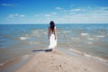 Young beautiful brunette woman in white dress on the seashore. Royalty Free Stock Photo