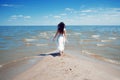 Young beautiful brunette woman in white dress on the seashore. Royalty Free Stock Photo