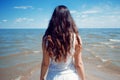 Young beautiful brunette woman in white dress on the seashore. Royalty Free Stock Photo