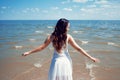 Young beautiful brunette woman in white dress on the seashore. Royalty Free Stock Photo