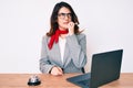 Young beautiful brunette woman working at hotel reception using laptop looking stressed and nervous with hands on mouth biting Royalty Free Stock Photo