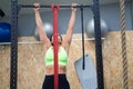 Young and beautiful brunette woman working out in the gym. The woman is exercising on a fixed bar and elastic band. She is wearing Royalty Free Stock Photo