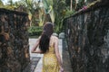 Young beautiful brunette woman in a yellow dress walks along a stone path Royalty Free Stock Photo