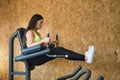 Young, beautiful, brunette woman in yellow top and black leggings, doing abdominal exercises with leg lifts at the gym. Fitness Royalty Free Stock Photo