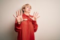 Young beautiful business blonde woman with short hair standing over  background afraid and terrified with fear expression Royalty Free Stock Photo