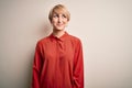 Young beautiful business blonde woman with short hair standing over isolated background smiling looking to the side and staring Royalty Free Stock Photo