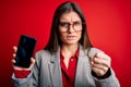 Young beautiful business woman with blue eyes holding smartphone showing screen annoyed and frustrated shouting with anger, crazy Royalty Free Stock Photo