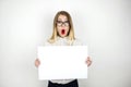 Young beautiful business woman in eyeglasses holding blank sheet of paper with announcement isolated white background Royalty Free Stock Photo