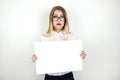 Young beautiful business woman in eyeglasses holding blank sheet of paper for announcement isolated white background Royalty Free Stock Photo