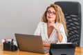 Young beautiful business woman is sitting confidently on her desk, to check her work.