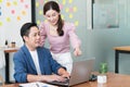 Young beautiful business woman Talking to her male Manager While pointing at his Computer on Table at workplace Royalty Free Stock Photo