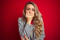 Young beautiful business woman wearing elegant jacket standing over red isolated background looking stressed and nervous with Royalty Free Stock Photo