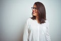 Young beautiful business woman wearing glasses over isolated background looking away to side with smile on face, natural Royalty Free Stock Photo