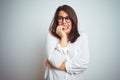 Young beautiful business woman wearing glasses over isolated background looking stressed and nervous with hands on mouth biting Royalty Free Stock Photo